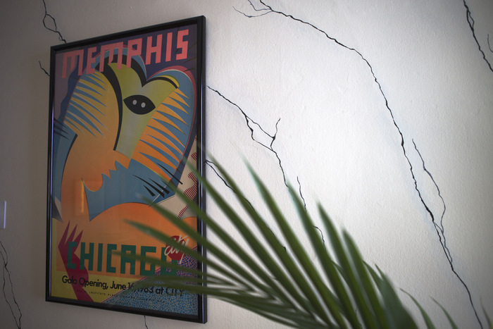 A marble-patterned wall featring a Memphis poster