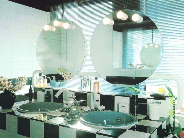'80s bathroom with circular mirrors and tungsten bulbs