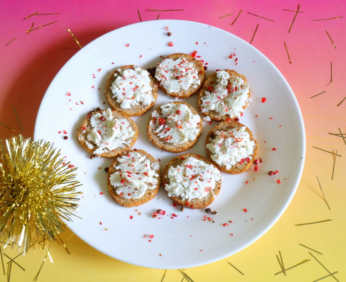 Crackers with goat cheese and pink peppercorn